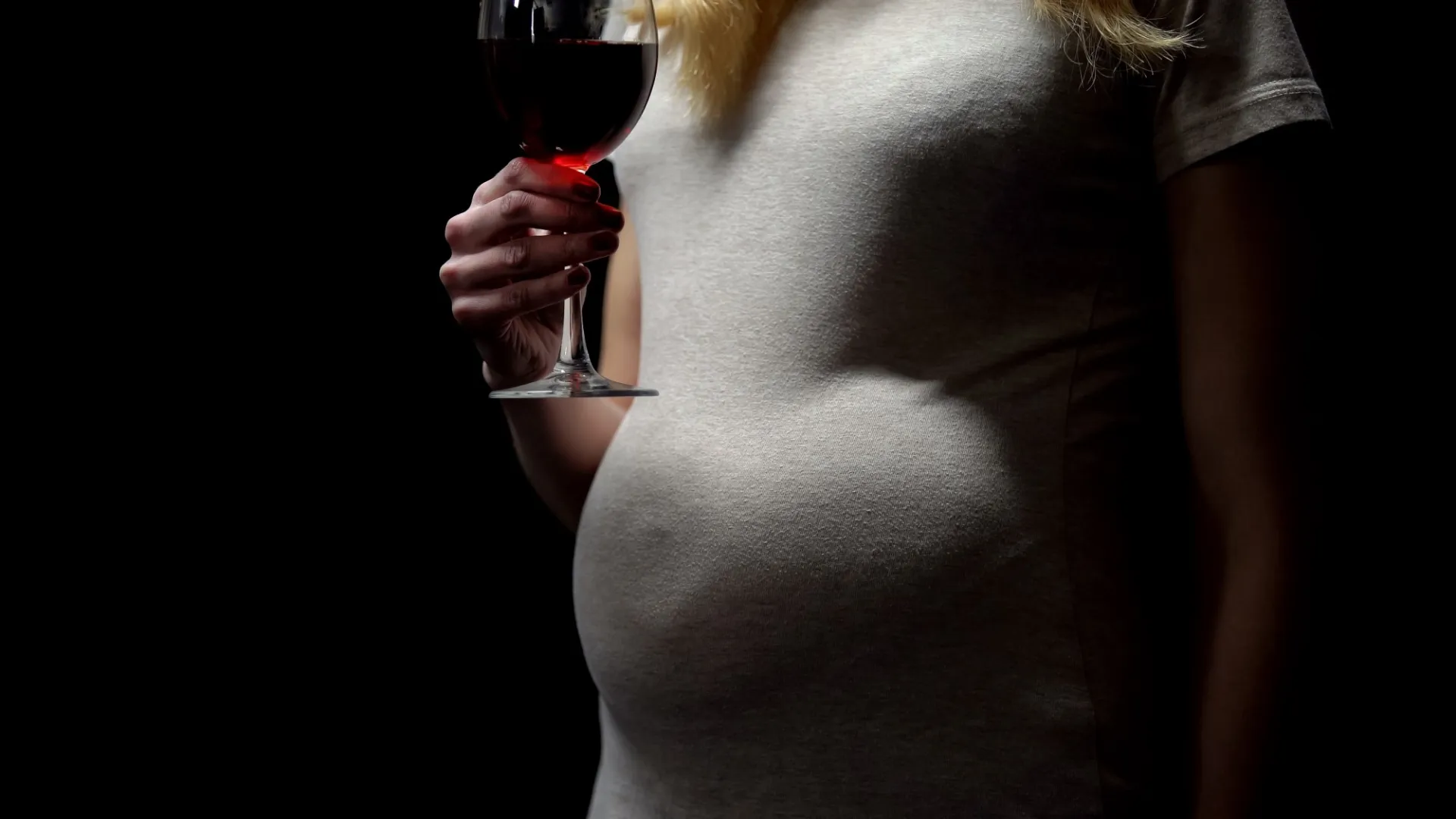 pregnant woman holding glass of wine