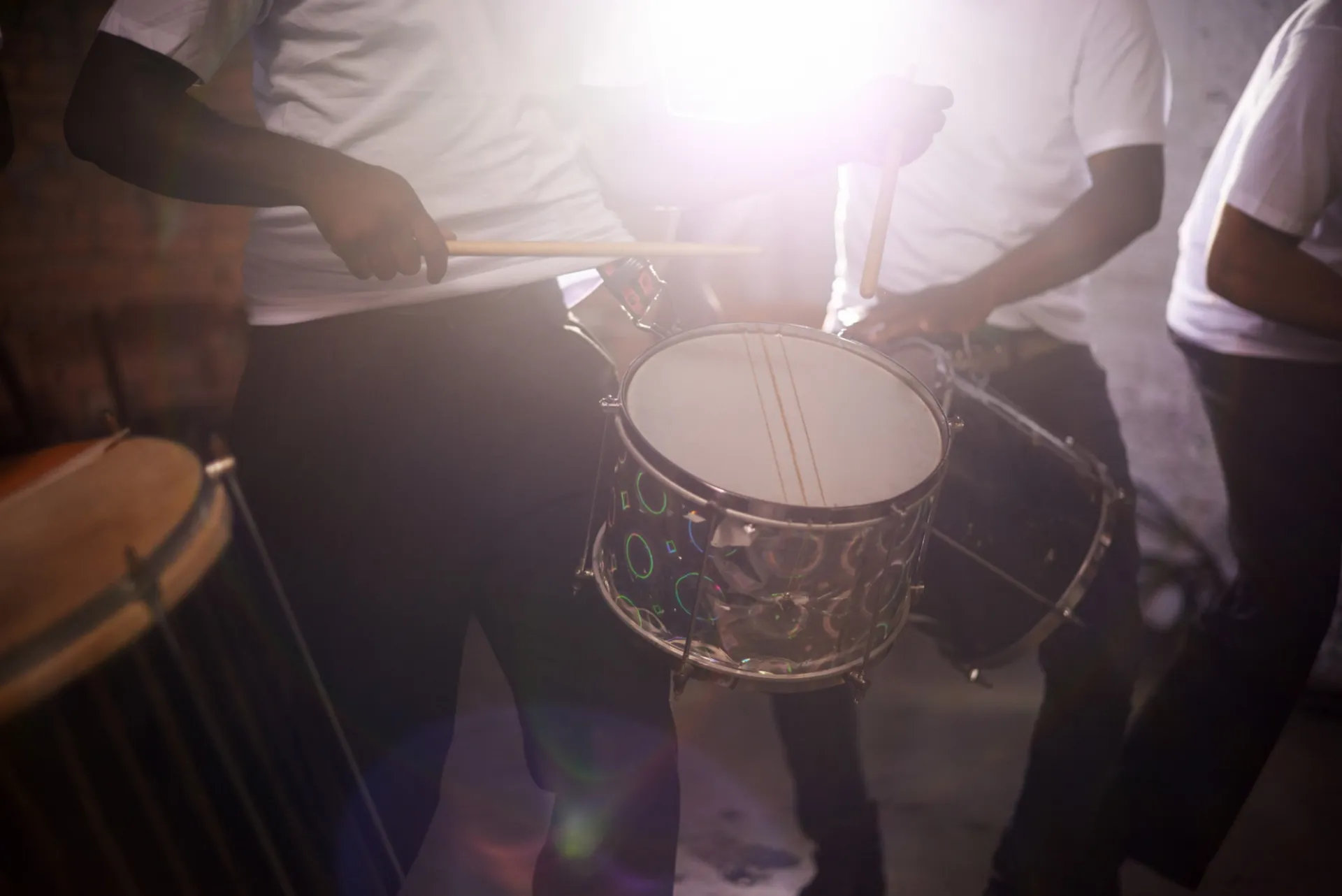 three people playing the drums
