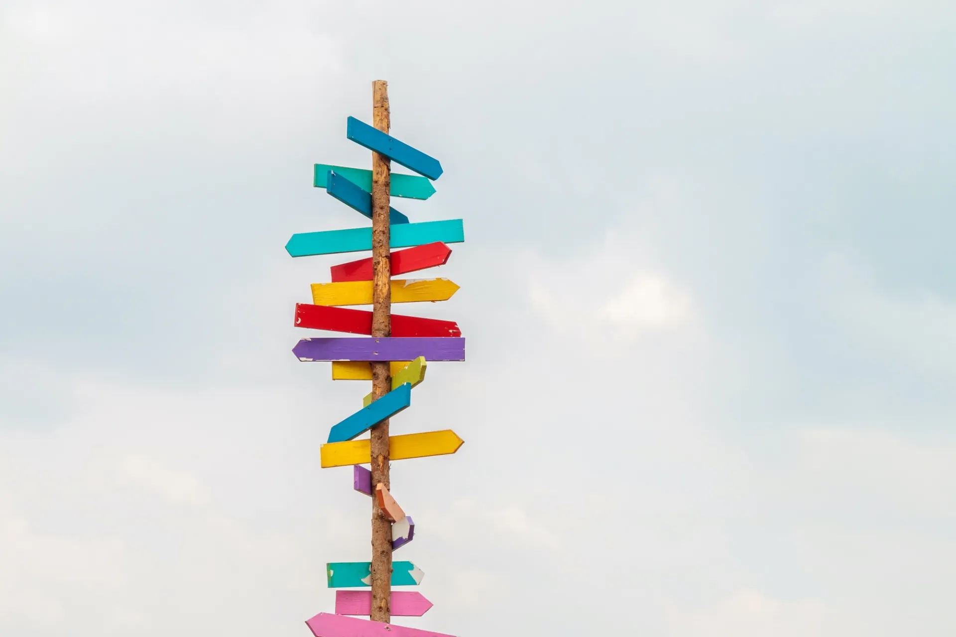 wooden post with attached signs pointing in different directions